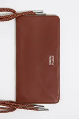 Minibolso negro de piel vacuna con textura granulada, formato rectangular y cierre de botón a presión. Incluye un tarjetero interior y dos asas: una de mano tipo cordón trenzado rojo y naranja, y una asa larga extraíble.