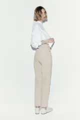 Jean tobillero de corte mom fit con cintura de tiro alto y diseño de cinco bolsillos en denim beige.