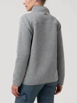 Polar de mujer color gris claro, con cierre frontal completo y cuello alto. Presenta un bolsillo vertical con cierre en el pecho y bolsillos laterales con cierre.