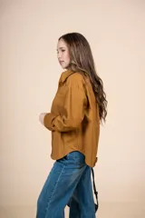 Camisa marrón de corte clásico, con tejido suave y textura cálida. Tiene un bolsillo decorativo discreto y botones al tono.