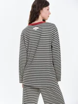 Remera de dormir de corte oversize con estampado de rayas horizontales, confeccionada en algodón con elastano. Presenta cuello redondo en rib de color rojo contrastante y mangas largas.