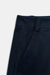 Pantalón barrel color azul marino, de tiro bajo, pernera holgada con diseño redondeado que se estrecha hacia el tobillo, con bolsillos delanteros y cierre frontal.
