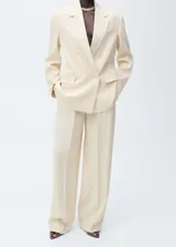 Pantalón de vestir color crema, de corte wide leg, con bolsillos laterales, pinzas delanteras y cierre oculto con botón, gancho y cremallera.