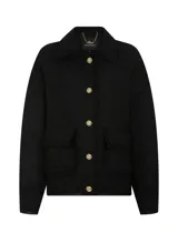 Chaqueta corta negra de tela tejida con cuello alto, mangas largas con puños abotonados, dos bolsillos delanteros con solapa y cierre frontal con botones.