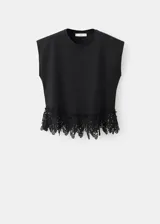 Camiseta negra de algodón con cuello redondo, mangas cortas y detalle de encaje en el borde inferior.