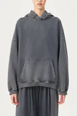 Buzo con capucha de silueta amplia y largo extendido, en color gris oscuro con efecto lavado o acid wash. Presenta un bolsillo canguro frontal y elástico en el borde de la capucha.