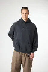 Hoodie de corte oversize color gris oscuro, con capucha, bolsillo frontal tipo canguro y logo pequeño bordado en el centro del pecho.