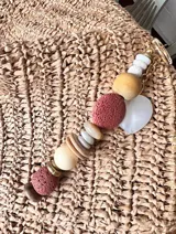 Colgante decorativo para bolso o llavero, compuesto por una cadena metálica con un conjunto de cuentas de diferentes formas, colores y texturas, incluyendo piedras naturales y cuentas de madera.