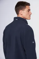 Campera de polar azul marino con cierre frontal completo, cuello alto y bolsillos laterales con cierre. Presenta un bolsillo vertical con cierre en el pecho y logo bordado.