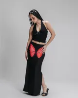 Falda larga negra de lycra con estampado de alas de mariposa rojas en la parte delantera.