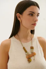 Vestido midi de tejido de punto en color beige, con cuello redondo y diseño sin mangas. Presenta un corte recto y holgado con una caída fluida.