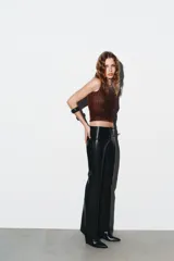 Top sin mangas, color azul marino, con cuello redondo y aplicación de brillos plateados que se dispersan desde el escote hacia el cuerpo.