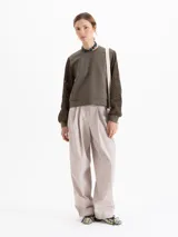 Buzo de calce regular con cuerpo de tela lisa y mangas largas de tejido calado con textura. Presenta escote redondo y puños ajustados.