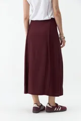 Falda midi de lino color beige, de tiro alto y corte recto, con abertura delantera y cierre cruzado sutil.