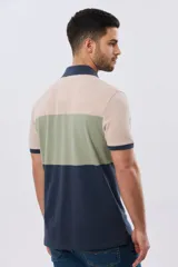 Remera polo de piqué con diseño de franjas horizontales en bloques de color, manga corta, cuello camisero y cartera de botones.