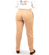 Pantalón de vestir color beige, de corte recto, con bolsillos laterales y traseros. Se ajusta a la cintura con cinturón de cuero marrón.