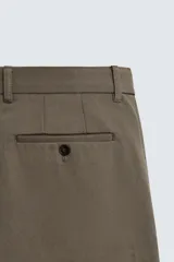 Pantalón de corte recto confeccionado en tejido compacto de algodón con estructura twill. Presenta cierre frontal con cremallera y botón, bolsillos laterales y bolsillos traseros de vivo con botón.