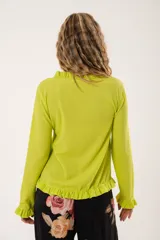 Blusa verde lima con textura arrugada, cuello redondo con volantes y mangas largas con puños elásticos.