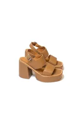 Sandalias de cuero color marrón con plataforma y taco ancho. Tienen dos tiras anchas sobre el empeine y una tira con hebilla al tobillo.