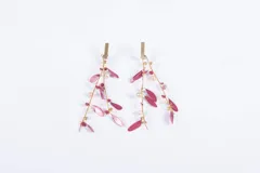 Aros colgantes dorados con detalles de pétalos color borgoña y cuentas de cristal.