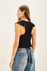 Musculosa de punto calado color crudo, con volados en las sisas y cuello redondo.