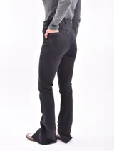 Pantalón de jean negro de tiro alto, corte recto y aberturas en el ruedo.