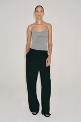 Pantalón de lana negro de tiro medio con trabillas en la cintura, bolsillos laterales ocultos y pierna ancha.