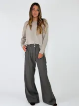Pantalon de vestir de corte sastrero y tiro alto, con pinzas frontales, cierre de doble botón y pernera ancha.