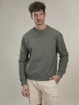 Sweater verde militar de cuello redondo y manga larga con detalle de bolsillo con solapa en la manga izquierda.