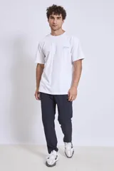 Pantalón de vestir azul marino, de corte recto, con bolsillos laterales y traseros. Se ajusta a la cintura con cinturón de cuero marrón.