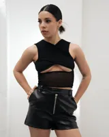 Short de tiro alto confeccionado en cuero sintético, con cierre frontal metálico a la vista y diseño estructurado.