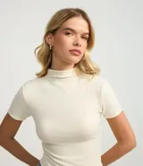 Blusa de cuello alto y manga corta, confeccionada en tejido rib texturizado. Presenta un diseño ajustado al cuerpo y acabado liso.