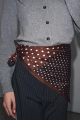 Pañuelo cuadrado de viscosa con estampado de lunares. Presenta un diseño dividido en cuatro secciones, alternando entre fondo marrón con lunares blancos y fondo negro con lunares blancos.