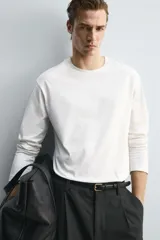 Camiseta de manga larga con corte relajado, confeccionada en algodón con acabado mercerizado y cuello redondo acabado en rib.
