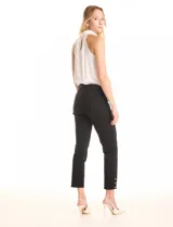 Pantalón pull-on negro de tiro alto con pretina ancha y elastizada. Silueta ajustada que termina por encima del tobillo, con aberturas decoradas con tres botones metálicos dorados en el lateral externo del ruedo.