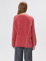 Remera de manga larga con cuello redondo, confeccionada en algodón con efecto lavado. Presenta costuras decorativas en color contrastante en sisas, mangas y frente, con un corte holgado y logo bordado en el frente.