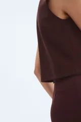 Top sin mangas color marrón oscuro, con cuello redondo y abertura frontal cerrada con tres botones dorados en forma de concha de mar.