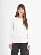 Remera de manga larga en color crema, con cuello redondo y ajuste entallado al cuerpo.