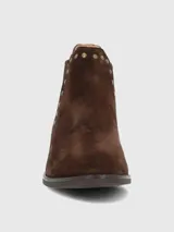 Bota corta tipo chelsea de gamuza color marrón, con detalle de tachas metálicas doradas a lo largo del elástico lateral y tacón bajo cuadrado.