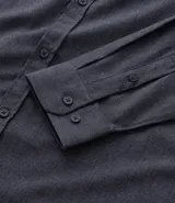 Camisa de manga larga confeccionada en tricolina de algodón, con cuello inglés, cierre frontal de botones y puños abotonados. Diseño liso y versátil.