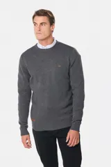 Buzo tejido de lana con escote redondo a la base, de manga larga y calce clásico. Presenta un pequeño detalle bordado en el pecho y una etiqueta decorativa en el ruedo.