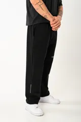 Pantalón recto unisex de corte oversize, color negro, con detalle bordado en la parte inferior de la pierna.