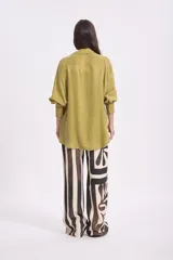 Camisa de manga larga color verde oliva, con cuello solapa y botones frontales. Corte holgado.