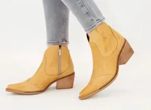 Botas texanas de caña baja confeccionadas en cuero vacuno con acabado estilo vintage, cuentan con cierre lateral y taco cuadrado de madera.