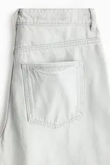 Pantalón de jean color gris claro, de tiro alto y diseño baggy con corte holgado en la cadera y piernas anchas estilo balloon.