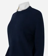 Suéter de punto gris con cuello redondo y diseño de cuello camisero celeste superpuesto. Presenta mangas largas y terminaciones acanaladas en puños y cintura.