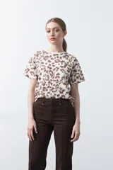 Remera de manga corta con estampado animal print en tonos blanco, marrón, beige y celeste.