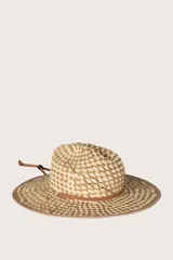 Sombrero de paja tejido en color natural y beige, con cinta marrón alrededor de la base de la copa y tira de ajuste de cuero.