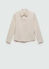 Camisa de estilo vaquero confeccionada en algodón, con cuello camisero, cierre frontal con botones metálicos y mangas largas con puños abotonados. Presenta un diseño entallado con costuras frontales.