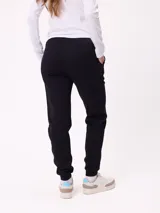 Pantalón tipo babucha de algodón y poliéster, con cintura elástica ajustable mediante cordón, bolsillos laterales y puños elásticos en los tobillos. Presenta un pequeño logo bordado en la pierna izquierda.